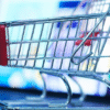 Desarrollo de tiendas online y plataformas e-commerce Carrito de compras metálico frente a una pantalla con una tienda online